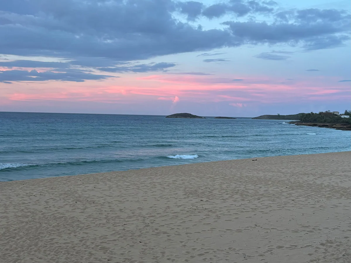 Playa y océano al atardecer vistos desde el lugar de la celebración